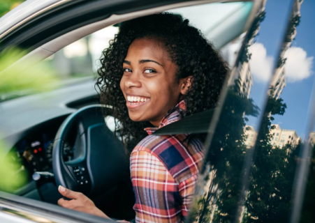Patient smiling behind the wheel after a dental appointment, illustrating driving after root canal treatment when it is safe to do so.